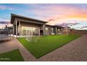 Backyard view showcasing well-maintained artificial turf, gravel landscaping, and outdoor recreational equipment at 19726 E Vallejo St, Queen Creek, AZ 85142