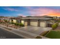 Angle shot of the house highlighting the three-car garage, desert landscaping, and modern architectural details at 19726 E Vallejo St, Queen Creek, AZ 85142