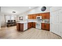 Well-lit kitchen with wooden cabinets, white appliances, and adjacent dining area at 2724 S Chaparral Rd, Apache Junction, AZ 85119