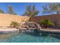 Beautiful pool and spa area with stone waterfall feature and lush landscaping at 3804 W Ashton Dr, Anthem, AZ 85086