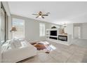 Bright living room featuring tile floors, a ceiling fan and a built-in entertainment center with fireplace at 41309 N Belfair Way, Anthem, AZ 85086