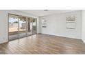 Bright living room with wood-look tile flooring, large sliding glass doors, and plenty of natural light at 9522 W Luxton Ln, Tolleson, AZ 85353