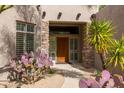 Close up of the main door and desert plants, including cactus and a manicured yard at 9626 E Peak View Rd, Scottsdale, AZ 85262