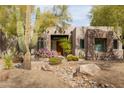 Attractive desert home with cacti, desert landscaping, and a stone accent exterior at 9626 E Peak View Rd, Scottsdale, AZ 85262