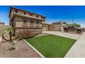 Two-story home with a 2-car garage, stone accents, and neat front lawn at 11728 W Villa Hermosa N Ln, Sun City, AZ 85373