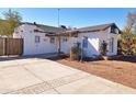 Exterior of a white home with a concrete driveway and a well-maintained landscape at 1541 W Culver St, Phoenix, AZ 85007