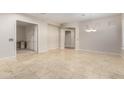 Open-concept living space featuring travertine floors, an arched doorway, and ample natural light at 27250 N 86Th Ave, Peoria, AZ 85383
