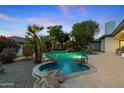 A sparkling in-ground pool with hot tub and waterfall feature enhances this home's outdoor living space at 4914 N Valley Gln, Litchfield Park, AZ 85340