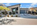 A modern home with desert landscaping is accented by a blue garage door at 727 E Monte Way, Phoenix, AZ 85042