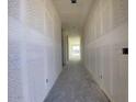 Unfinished hallway with drywall, leading to a bright window at the end, showcasing the construction stage at 9521 W Luxton Ln, Tolleson, AZ 85353