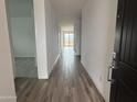 A brightly lit hallway featuring durable tile flooring and leading to various rooms in the home at 9525 W Luxton Ln, Tolleson, AZ 85353