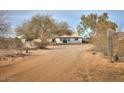 Wide exterior shot showing the property with desert landscaping and a long dirt driveway at 15076 W Belmont Dr, Casa Grande, AZ 85194