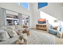 Bright living room with high ceilings, large windows and comfortable seating and media center at 1957 W Lonesome Trl, Phoenix, AZ 85085
