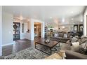 Spacious, open-concept living room with hardwood floors, a modern rug, comfortable seating, and views into the dining and kitchen areas at 22805 W Hopi St, Buckeye, AZ 85326