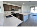 Modern kitchen with stainless steel appliances, quartz countertops, and a center island overlooking the backyard at 23252 W Miami St, Buckeye, AZ 85326