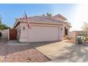 Exterior view showcasing the home's garage and desert-style front yard at 3403 E Kristal Way, Phoenix, AZ 85050