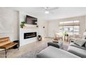 Cozy living room with a fireplace, a gray sofa, and a large window for natural light at 406 W Riviera Dr, Tempe, AZ 85282