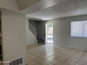 Spacious living room showcasing tiled flooring, staircase, and sunlit windows at 4424 E Pueblo Ave, Phoenix, AZ 85040