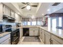Well-lit kitchen features granite counters, neutral cabinets, black appliances, and a window over the sink at 556 W Kiva Ave, Mesa, AZ 85210