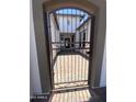 Metal gate with access to the courtyard with stone pavers and view to the front of the house at 5741 E Star Valley St, Mesa, AZ 85215