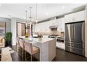 Modern kitchen with white cabinets, stainless steel appliances, and a large island with seating at 6990 E 6Th St # 1016, Scottsdale, AZ 85251
