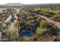 Stunning aerial view of a luxurious home with a private pool, beautifully landscaped backyard, and mature trees at 8057 E Greythorn Dr, Gold Canyon, AZ 85118