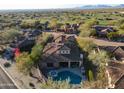 Aerial view of a stunning home with a backyard oasis featuring a sparkling pool, spa, and covered patio at 8057 E Greythorn Dr, Gold Canyon, AZ 85118