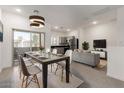 Dining area with modern light fixture, table with seating and open kitchen and living space at 8255 N 22Nd Dr, Phoenix, AZ 85021