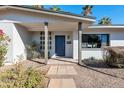 A close up of the front entrance with a modern blue door and desert landscaping at 9821 N 29Th Pl, Phoenix, AZ 85028