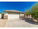 Attached two-car garage with a long driveway and stone facade at 16410 W Monte Cristo Ave, Surprise, AZ 85388