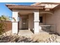 A cozy front porch features an archway, a security door and a small gated front patio at 16848 W Bradford Way, Surprise, AZ 85374