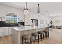 Bright, open kitchen features a large island with marble countertop and stylish pendant lighting at 18344 W Santa Irene Dr, Goodyear, AZ 85338