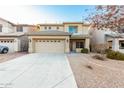 Inviting two-story home showcasing a wide driveway and desert landscaping, plus a neutral color scheme at 22500 N Greenland Park Dr, Maricopa, AZ 85139