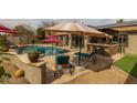 Resort-style backyard with a sparkling pool, outdoor kitchen, and comfortable lounge seating for ultimate relaxation at 2501 E Milky Way, Gilbert, AZ 85295