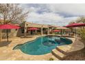 Beautiful backyard featuring a kidney-shaped pool, spa, and shaded patio with ample seating, perfect for entertaining at 2501 E Milky Way, Gilbert, AZ 85295