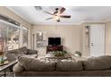Comfortable living room with large windows, plush seating, and a ceiling fan at 2600 E Springfield Pl # 61, Chandler, AZ 85286