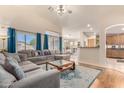 Open-concept living room with a large sectional, hardwood floors, and access to the kitchen at 2662 S Iowa St, Chandler, AZ 85286