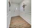 Inviting entryway features wood-look flooring, paneled walls, decorative wall art, and a bright front door at 3728 E Grove Ave, Mesa, AZ 85206