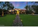Stately home with lush lawn and illuminated stone pathway leading to the front entrance at 5710 E Camelback Rd, Phoenix, AZ 85018