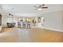 Spacious living room with wood floors seamlessly connecting to an open kitchen and breakfast nook at 6206 W Buckhorn Trl, Phoenix, AZ 85083