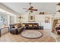 Comfortable living room featuring a leather sectional sofa and a vaulted ceiling with accent beams at 10718 E Fenimore Rd, Mesa, AZ 85207