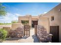 Front entrance featuring a brick wall and wooden entry gate at 11199 E Prospect Point Dr, Scottsdale, AZ 85262