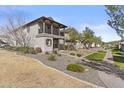 Well-maintained two-story home featuring desert landscaping with green grass and rock accents at 12343 W Essig Way, Peoria, AZ 85383