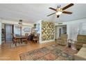 Spacious living room featuring wood floors, a ceiling fan, and an adjacent dining area at 18826 N 134Th Ave, Sun City West, AZ 85375