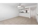 Bright living area with neutral tile flooring, ceiling fan, and open flow to the kitchen at 19601 N 7Th St # 1009, Phoenix, AZ 85024