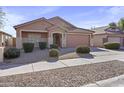 Charming home with a two-car garage, desert landscaping, and a welcoming front entrance at 22177 E Calle De Flores --, Queen Creek, AZ 85142