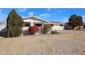 Single story home features manicured landscaping, with bright bushes and trees in the front yard at 3716 W Griswold Rd, Phoenix, AZ 85051