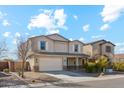 Two-story home featuring a two-car garage, neutral stucco, shuttered windows, and low maintenance landscaping at 37292 N Yellowstone Dr, San Tan Valley, AZ 85140
