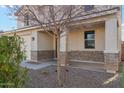 Covered front porch with stone accents, a brown front door, and side panel window at 37292 N Yellowstone Dr, San Tan Valley, AZ 85140