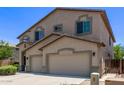 Side view of a two-story house with a three-car garage and desert-friendly landscaping at 42735 W Bravo Dr, Maricopa, AZ 85138